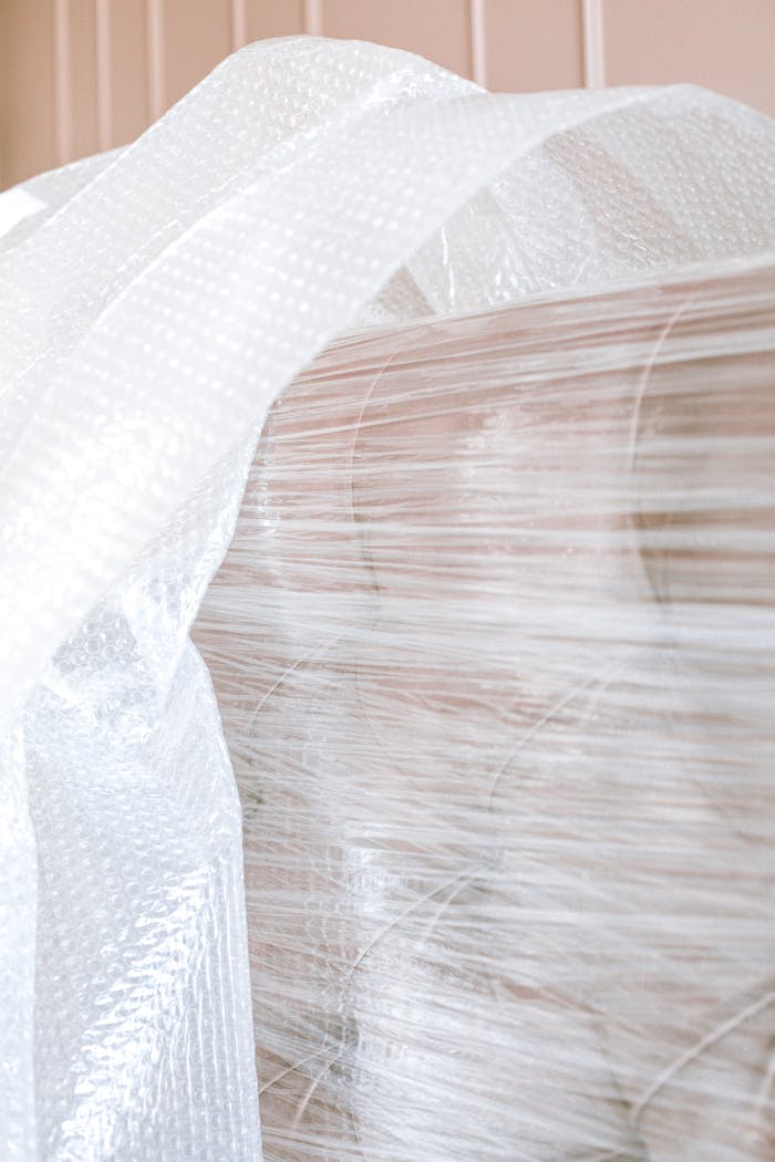 Close-up of a sofa wrapped in bubble wrap, ready for moving or storage.